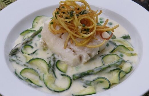 Milk Poached Cod over Creamy Dill Spring Greens topped with a Crispy Garlic Chive Potato Nest